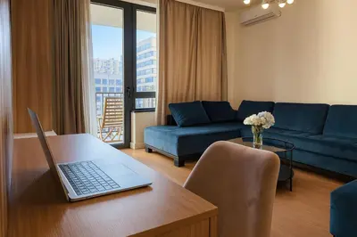 a living room with a laptop on a wooden table at Echo Residence - Belgrade Waterfront in Belgrade