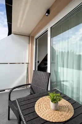 a patio table with a potted plant on a balcony at Giorgio Luxury Suites in Belgrade