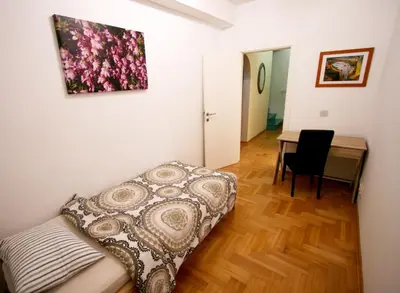 a bedroom with a bed and a desk with a table at Apartment Grande centar with parking in Belgrade