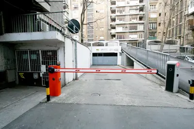 a gate in a parking lot next to a building at Apartment Grande centar with parking in Belgrade