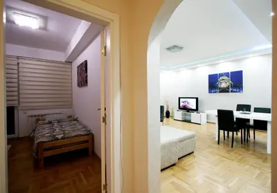 a bedroom with a bed and a dining room with a table at Apartment Grande centar with parking in Belgrade