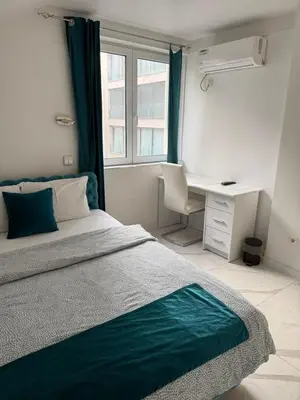 a bedroom with a bed and a desk and a window at Teddy Luxury Suites in Belgrade