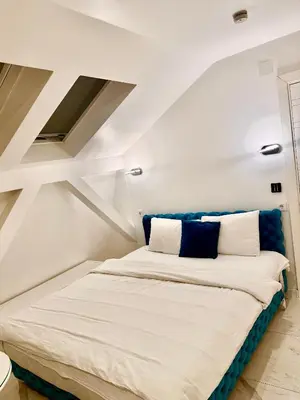 a bedroom with a large bed with blue and white pillows at Teddy Luxury Suites in Belgrade