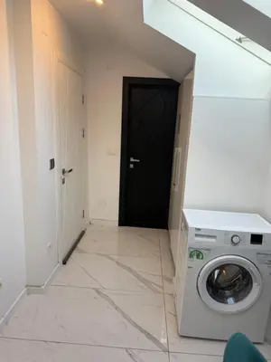 a washing machine in a room with a black door at Teddy Luxury Suites in Belgrade