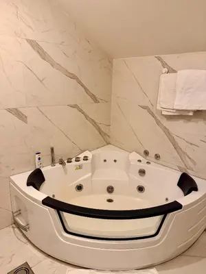 a white bath tub in a bathroom with marble walls at Teddy Luxury Suites in Belgrade