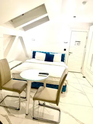 a bedroom with a bed and a table and chairs at Teddy Luxury Suites in Belgrade