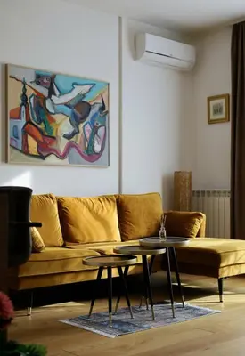 a living room with a yellow couch and a table at W65 ElegantStay II in Belgrade