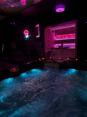 a room with a hot tub with purple and blue lights at Flex Lux Spa Apartment Belgrade with Jacuzzi and Sauna in Belgrade