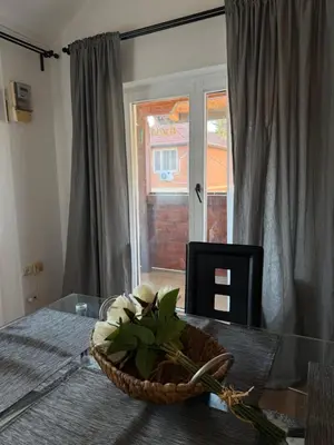 a basket of flowers on a glass table with a window at Apartman Tara in Belgrade