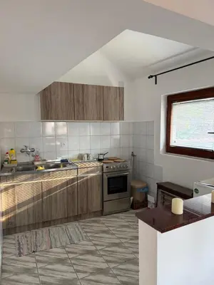 a kitchen with wooden cabinets and a stove top oven at Apartman Tara in Belgrade