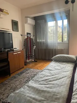 a bedroom with a bed and a flat screen tv at Spacious apartment with 2 bedrooms in City Center, near Parliament and St Marks Church in Belgrade