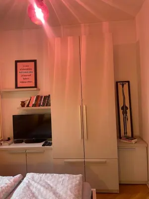 a bedroom with a white cabinet and a tv at Spacious apartment with 2 bedrooms in City Center, near Parliament and St Marks Church in Belgrade