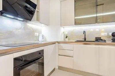 a white kitchen with white cabinets and a sink at Belgrade Waterfront - Beograd na Vodi - Sensa 3 in Belgrade