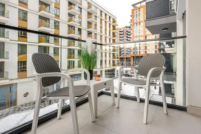 a balcony with two chairs and a table on a building at Belgrade Waterfront - Beograd na Vodi - Sensa 3 in Belgrade