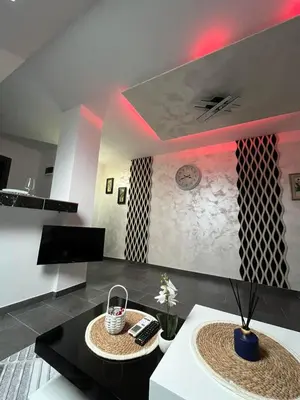 a living room with a black counter top and red lighting at Crassula Lux 4 in Surčin