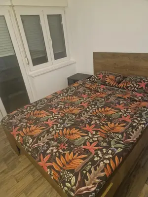 a bed with a colorful blanket on top of it at Centro apartman 3 in Pančevo