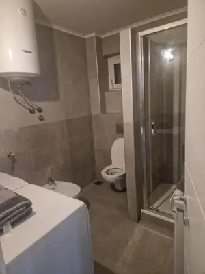 a bathroom with a toilet and a sink and a shower at Centro apartman 3 in Pančevo