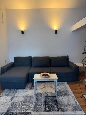 a blue couch in a living room with a table at Apartman Tara in Belgrade