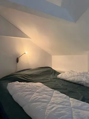 a bedroom with two unmade beds and a lamp at Apartman Tara in Belgrade
