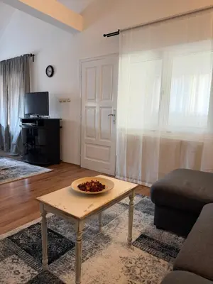 a living room with a table in front of a door at Apartman Tara in Belgrade