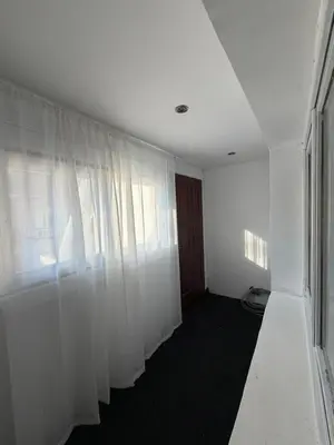 an empty room with white curtains and a window at Apartman Tara in Belgrade