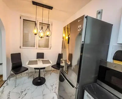 a kitchen with a table and a refrigerator at LOLA home in Beograd
