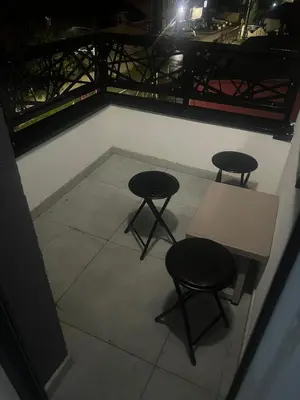two chairs and a table and two stools in a room at Harmony Apartment in Surčin