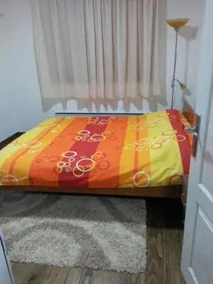 a bed with a colorful comforter in a bedroom at Sweet Dreams Apartment in Arandjelovac