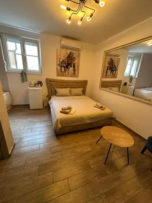 a bedroom with a bed and a table and a mirror at Urban Escape Zemun in Belgrade