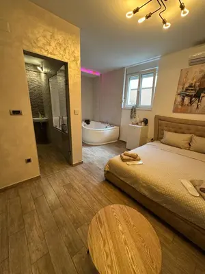 a bedroom with a bed and a tub and a table at Urban Escape Zemun in Belgrade