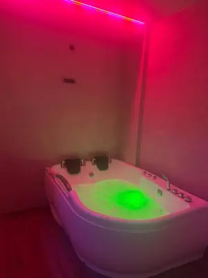 a white bath tub with green dye in a room at Urban Escape Zemun in Belgrade