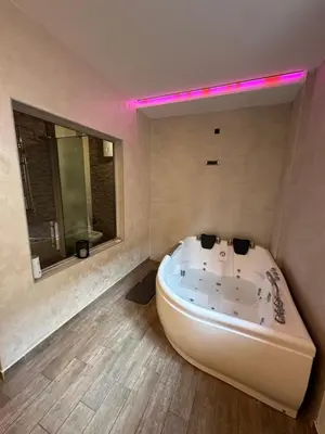 a large white tub in a bathroom with a mirror at Urban Escape Zemun in Belgrade