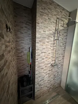 a bathroom with a shower in a brick wall at Urban Escape Zemun in Belgrade