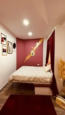 a bedroom with a bed with a pink wall at Low cost studio Zeleni Venac in Belgrade