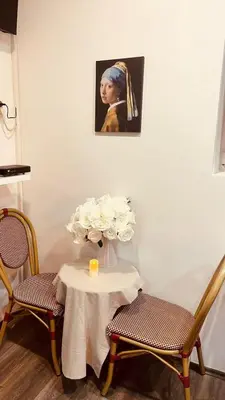 a table with a vase of flowers and a painting at Low cost studio Zeleni Venac in Belgrade