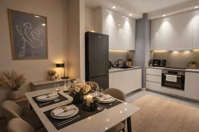 a kitchen with a table and chairs and a refrigerator at Metropoliten Modern Apartment in Belgrade