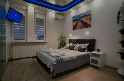 a bedroom with a large bed and a tv at Moon in Belgrade