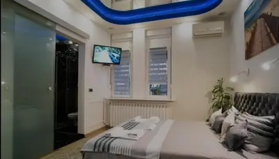 a bedroom with a bed and a tv on the wall at Moon in Belgrade