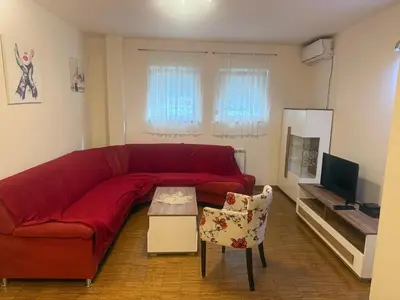 a living room with a red couch and a tv at City Center Apartment Cvijiceva in Belgrade