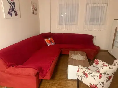 a red couch in a living room with a table at City Center Apartment Cvijiceva in Belgrade