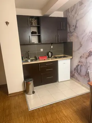 a kitchen with black cabinets and a marble wall at City Center Apartment Cvijiceva in Belgrade