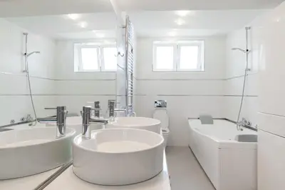 a white bathroom with two sinks and a tub at Apartment 18 in Belgrade