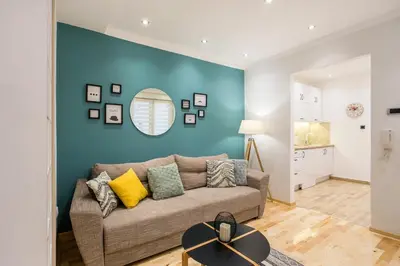a living room with a couch and a blue wall at Cozy City Center Nest - Quiet Courtyard Patio in Belgrade