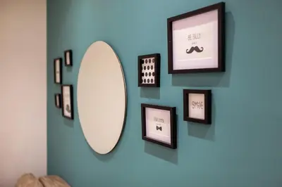 a mirror on a blue wall with framed pictures at Cozy City Center Nest - Quiet Courtyard Patio in Belgrade