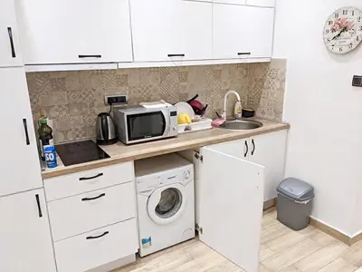 a kitchen with a microwave and a washing machine at Cozy City Center Nest - Quiet Courtyard Patio in Belgrade