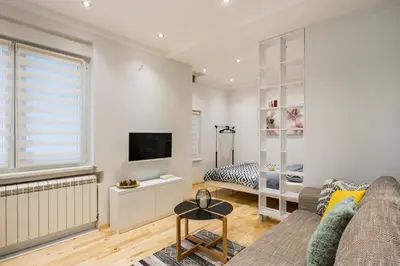 a living room with a couch and a television at Cozy City Center Nest - Quiet Courtyard Patio in Belgrade