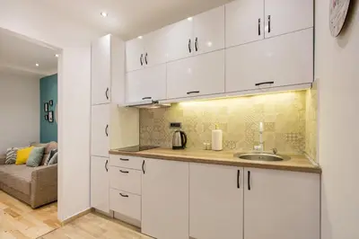 a kitchen with white cabinets and a sink at Cozy City Center Nest - Quiet Courtyard Patio in Belgrade