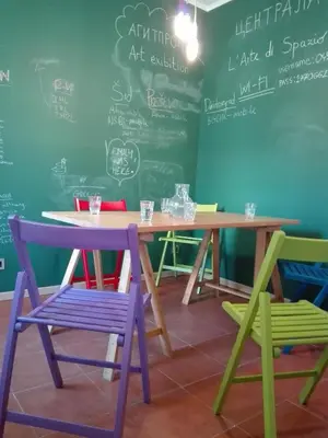 a table with colorful chairs and a chalkboard at Centrala Apartment in Belgrade