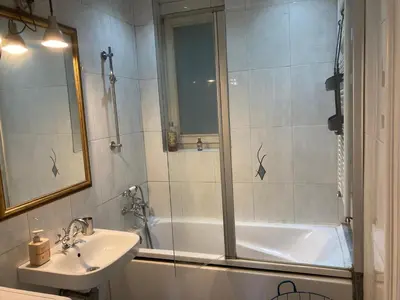 a bathroom with a shower and a sink and a tub at Centrala Apartment in Belgrade