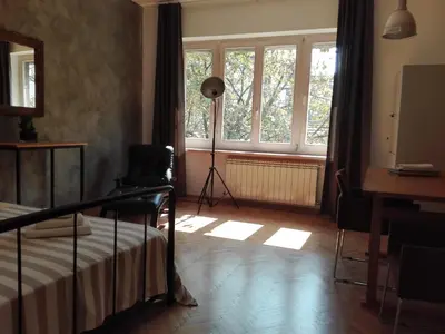 a bedroom with a bed and a window and a lamp at Centrala Apartment in Belgrade